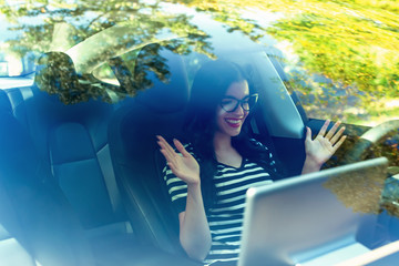 Woman in a self-driving autonomous electric vehicle with hands off the steering wheel