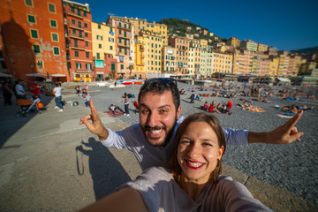 Fototapeta na wymiar Tourists happy couple taking selfie photo of Camogli, amazing beach near Cinque Terre, Liguria, Italy, Europe. Concept travel.