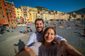 Tourists happy couple taking selfie photo of Camogli, amazing beach near Cinque Terre, Liguria,...