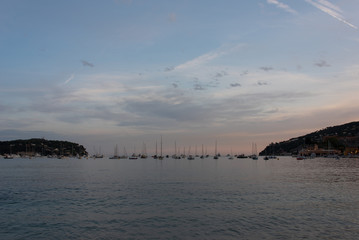 Sunset in Villefranche-sur-Mer, Cote d'Azur, France. Boats under cloudy sky. Long exposure. 