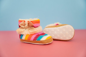 colorful baby boots on pink and blue background