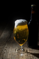 Frisches Pils im Glas mit überlaufendem Schaum