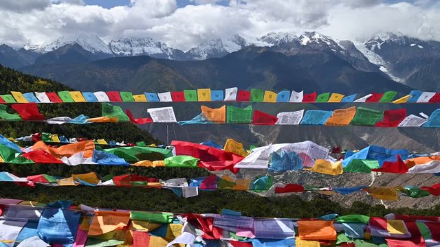 Tibetan buddhist prayer flags blowing in the wind with Meili snow mountain in backgroung in Yunnan, China