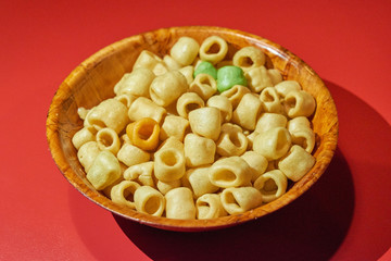 Macaroni Cookies in Wooden Bowl on Red Background
