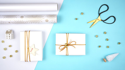 Christmas holiday flat lay miminal composition of gift wrapping in white, gold and pale blue theme.