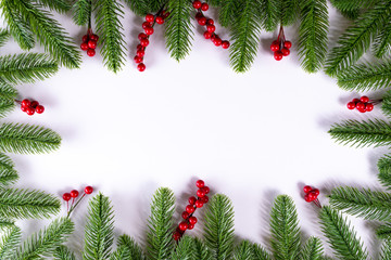 Christmas background with fir branches and holly berries. Copy space.