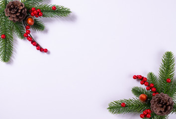 Christmas background with fir branches, pine cone and holly berries. Copy space.