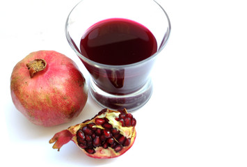 Glass of pomegranate juice and pomegranate fruit