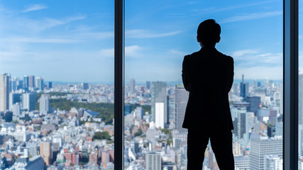 businessman wearing suit looking cityscape of tokyo