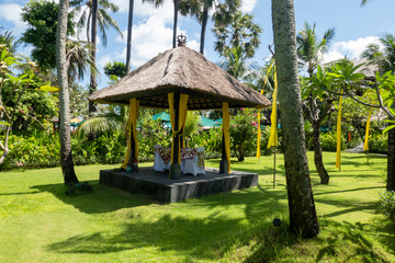 Traditional thatched gazebo provide shade in the tranquil tropical landscape garden