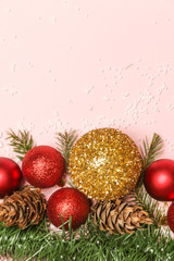 Christmas ornaments and fir twigs arrangement with copy space on pale pink background.