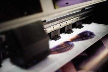 Large inkjet printer with printing on vinyl paper with lighting in workplace