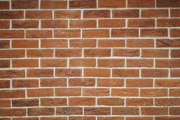 Fototapeta premium Red brick wall closeup. Abstract background. Brickwork and glue, gray seams between bricks.