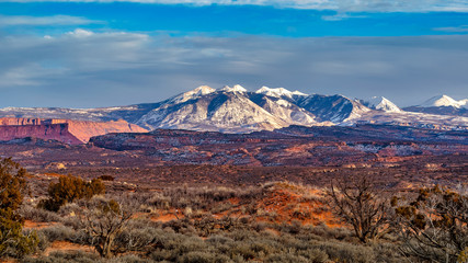 Snow peaked mountains across the desert landscape in Arches National Park near Moab, Utah, USA right before sunset. © S Quintans