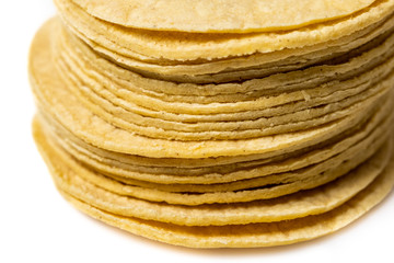 Heap of yellow corn mexican tortillas on white background