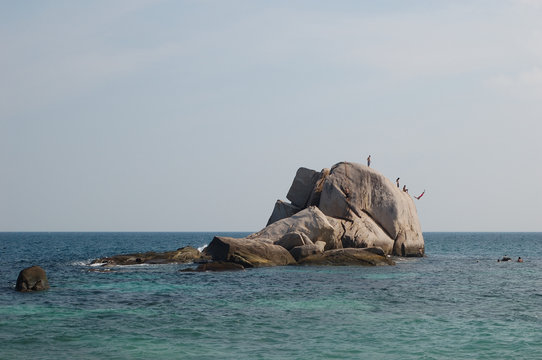 People jumping from the sea roack in Ao Tanot (Tanote Bay) in Koh Tao, Thailand