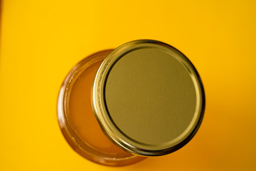 Jar of Organic Honey on Yellow Background