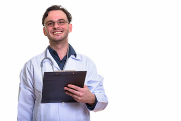 Studio shot of young happy man doctor smiling while holding clip