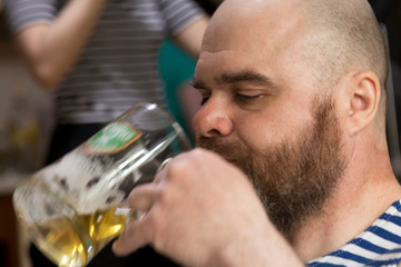 Portrait of a bearded man with a beer