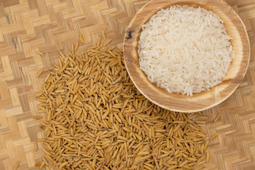 Rice in wooden bowl on paddy rice background