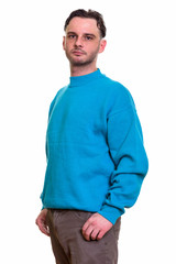 Studio shot of man standing and wearing blue sweater