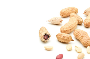 Peanuts and almonds lie next to fried kernels of peanuts on a white background.