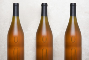 Chardonnay Wine: Top view of a three bottles on a concrete counter top.