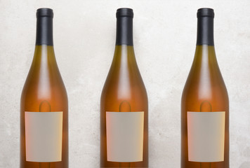 Chardonnay Wine: Top view of a three bottles with blank labels on a concrete counter top.