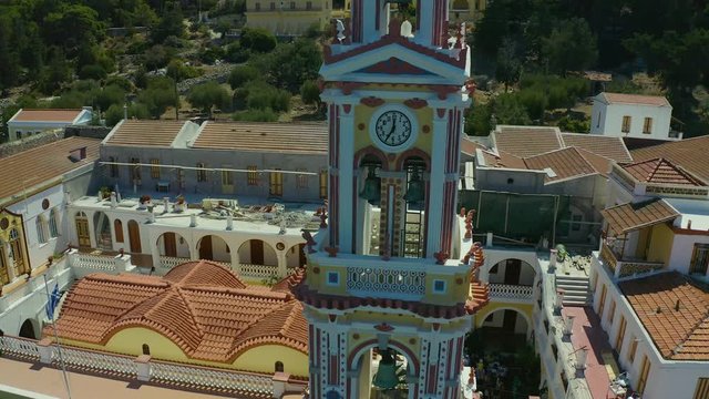 fly around the chapel and tower of panormitis monastery, Simi island Greece, overlooking the Bay and surrounding area. 4K drone video