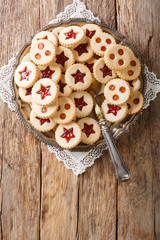 Christmas Linzer cookies stuffed with strawberry and apricot jam  close-up on the plate. Vertical top view