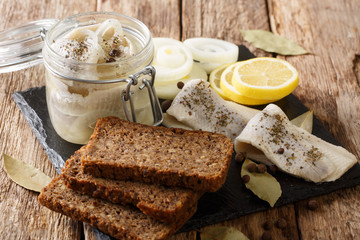 Polish salted herring with onions, vinegar, spices in oil in a jar close-up on the table. horizontal