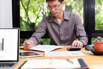 Fototapeta premium Small and Medium Enterprise Business concept of ,Businessman using calculator to calculate Assets Chart