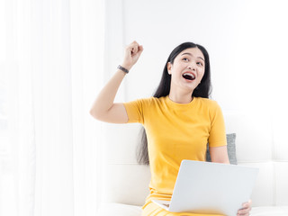 Asian woman in yellow dress using lapto at home, lifetyle concept.