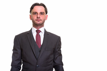 Studio shot of young businessman in suit looking at camera