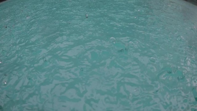 Video of rain splashing into pool. Storm in Panama City. Close up of swimming pool during storm and rain drops falling into water. Equatorial climate.