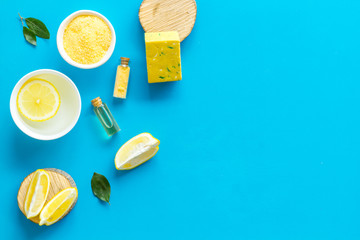 Lemon cosmetics. Cleansing tonic and handmade soap on blue background top view frame copy space