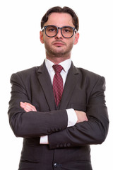 Studio shot of young businessman wearing eyeglasses with arms cr