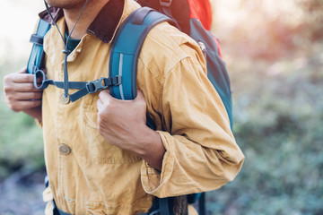 Fototapeta na wymiar close up hand holding backpack man hiking traveling on forest in travel Lifestyle wanderlust adventure with enjoying on nature. Tourist traveler on background valley landscape view. focus to hand.