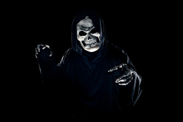 Scary monster or grim reaper ghost coming out of the dark shadows to haunt during Halloween.  Depicts a scary and deadly fictitious demon © Innovated Captures