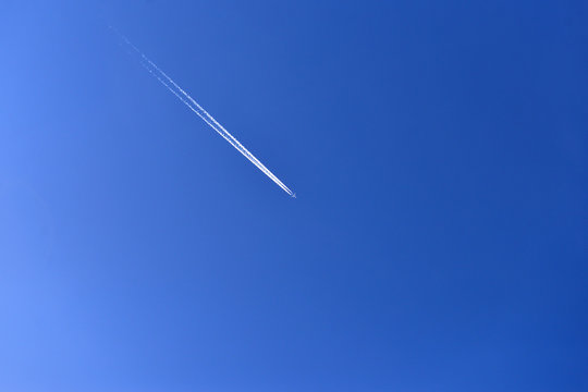 Airplane in the blue sky. Trace of an airplane in the sky during the day. Minimalist photo. Flight
