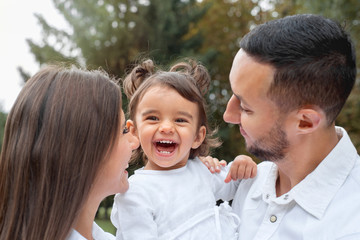 Fototapeta premium Happy little girl laught with her parents in the park