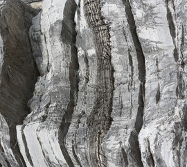 Background on the basis of the texture of rock. The gray stone surface with vertical stripes