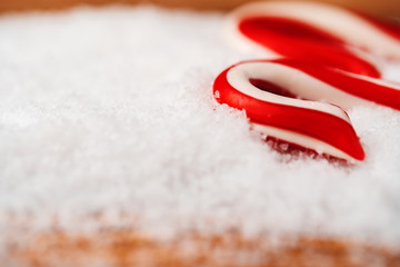 Close up of candy cane on snowy table