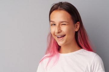 Obraz premium Portrait of joyful cute teen girl laughing over a gray background