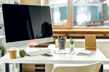 Office  or home workspace. Computer monitor with black screen on office table with supplies