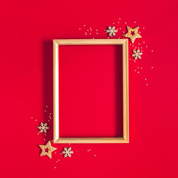 Christmas composition. Photo frame, golden and red decorations on red background. Christmas, winter, new year concept. Flat lay, top view, copy space