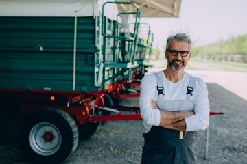 mid aged agronomy worker standing arms crossed outdoor