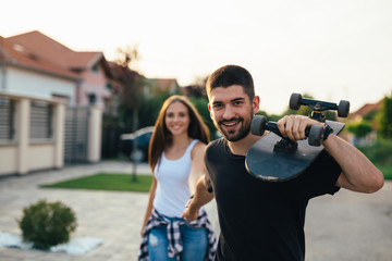 romantic couple outdoor holding skateboard