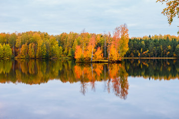 Beautiful autumn landscape. Reflection of the autumn forest in the lake.