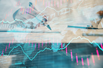 Double exposure of woman's hands making notes with forex graph hologram. Concept technical analysis.